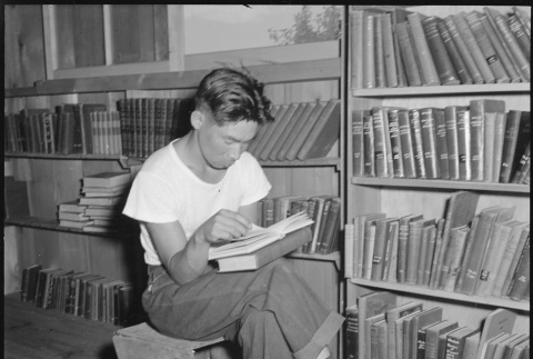 Japanese American reading in library (ddr-densho-151-435)