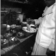 Man serving food into small bowls (ddr-densho-426-2151)