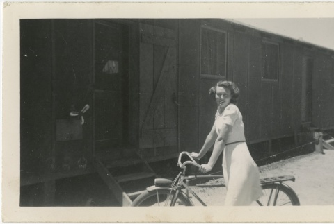 Woman on a bicycle outside barracks (ddr-manz-7-9)