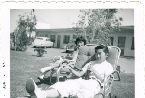 Two girls lounging outside with sodas (ddr-densho-430-215)