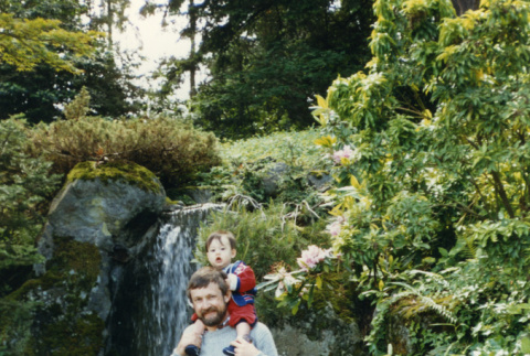 Family in front of a waterfall in the Garden (man and 3 children) [family] (ddr-densho-354-606)