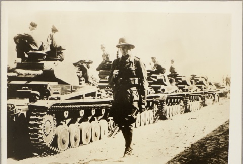 Italian officer walking past a line of tanks (ddr-njpa-13-821)