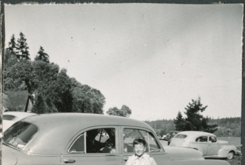 Chester Sakura Jr standing next to car (ddr-densho-523-208)