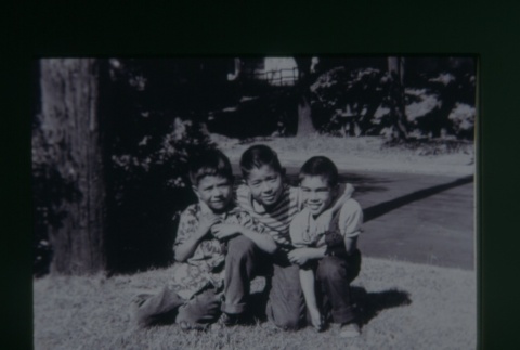 (Slide) - Image of three boys kneeling on grass (ddr-densho-330-131-master-d6f5faa4fb)