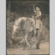 Boy in cowboy gear riding pony (ddr-densho-523-245)