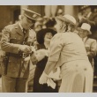 Man in military dress receiving flower and scroll from a woman (ddr-njpa-2-321)