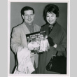 Mary Mon Toy with man holding album soundtrack for The World of Suzie Wong film (ddr-densho-367-194)