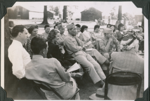 Group of men and women sitting outside (ddr-ajah-2-522)