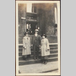Two women and a man posing in front of a building (ddr-densho-278-97)