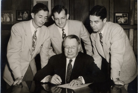 John H. Wilson signing a document while three men look on (ddr-njpa-2-905)