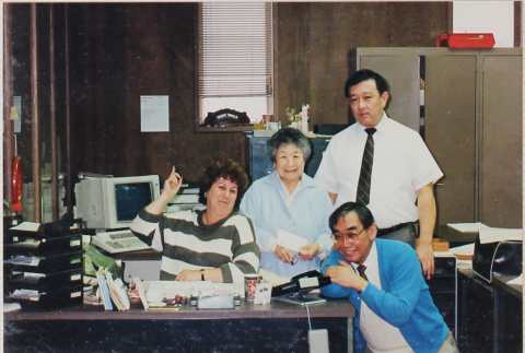 Four people around a desk (ddr-densho-426-1201)