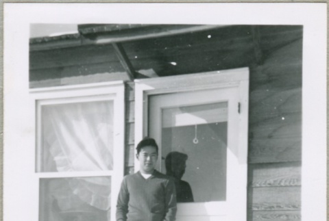 A man standing in the doorway of a housing project apartment (ddr-densho-300-59)
