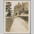 Man sitting on railing alongside road (ddr-densho-316-236)