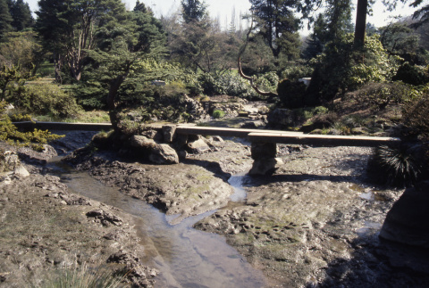 Creekbed looking upstream at Zig Zag Bridge with site of Heart Bridge in background (ddr-densho-354-2045)