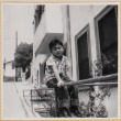 William Shiomi sitting on railing (ddr-densho-522-255)