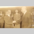 Men shaking hands while others look on (ddr-njpa-4-2553)