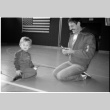 Man with child on gym floor (ddr-densho-1007-1258)