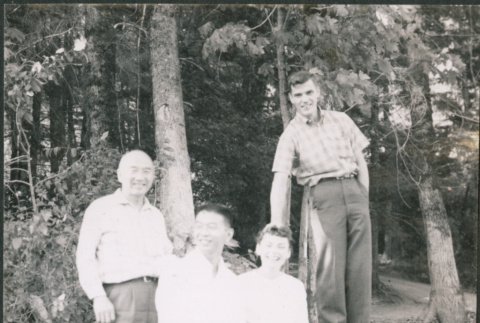 Chester Sakura Sr., with two men and a woman sitting on log (ddr-densho-523-338)