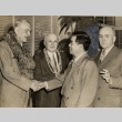 Two men shaking hands, Ingram Stainback and another man looking on (ddr-njpa-2-1185)