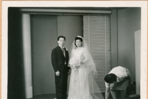 Henri Takahashi and Tomoye (Nozawa) Takakashi posed for photo, woman adjusting dress (ddr-densho-410-470)