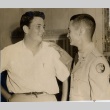Young man in military dress standing with another man (ddr-njpa-2-1055)
