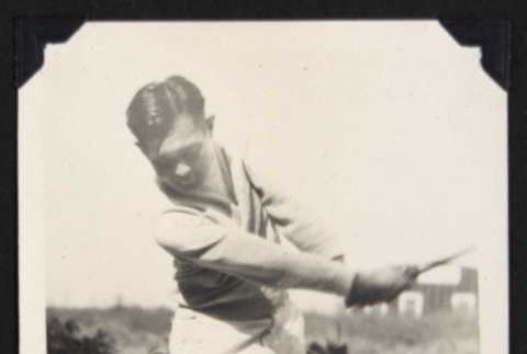 Man swinging a golf club (ddr-densho-542-722)