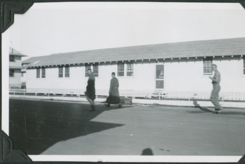 Men walking past barracks (ddr-ajah-2-160)