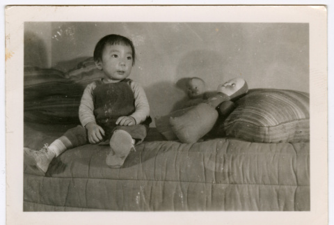 Child sitting on bed (ddr-densho-329-1349)