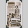 Photo of a woman and child with a dog in a crate in a wagon (ddr-densho-483-1225)