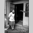 Woman in smock standing in doorway (ddr-densho-426-2298)