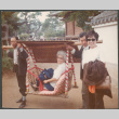 Agnes Sakura being carried by two men with another woman standing (ddr-densho-523-575)