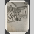 Man kneeling in front of Nazi flag (ddr-densho-466-666)