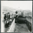 Photograph of three people standing next to Harmony Borax Works equipment in Death Valley (ddr-csujad-47-125)