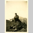 Soldier sitting on metal wreckage (ddr-densho-22-322)