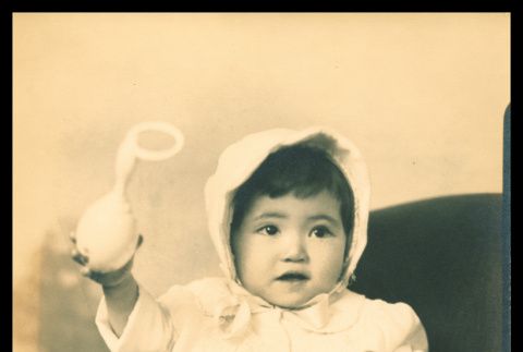 Baby holding rattle (ddr-csujad-55-1311)