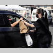 Woman handing bags to man in car (ddr-densho-512-50)