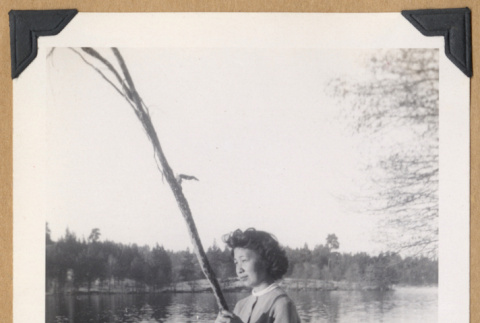 Woman posing on a fallen tree (ddr-densho-542-329)
