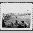 Football players sitting on bench watching game (ddr-densho-434-477)