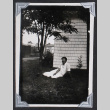 Young man lounges in a yard (ddr-densho-404-185)