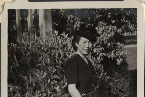 Woman standing in garden.  Likely Masu Muromoto (ddr-densho-466-918)