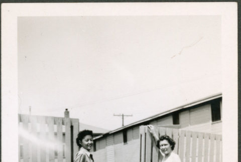Two women pose by fence (ddr-densho-368-533)