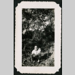 Walter Matsuoka kneels in a wooded area (ddr-densho-390-61)