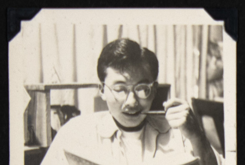 Eddie reading and smoking (ddr-densho-542-663)