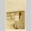 Woman standing in front of camp barrack (ddr-csujad-37-3)