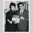 Mary Mon Toy with man holding album soundtrack for The World of Suzie Wong film (ddr-densho-367-196)