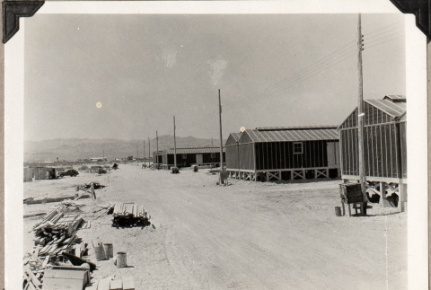 Row of barracks and lumber piles (ddr-densho-587-83)