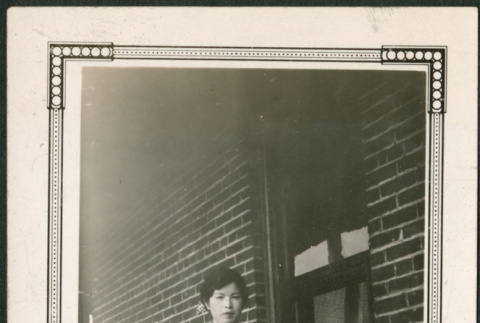 Woman standing by brick wall (ddr-densho-293-109)