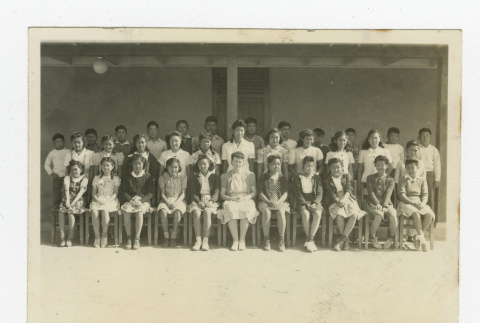 Group of Nisei 7th graders with a teacher outside a barrack (ddr-csujad-44-31)