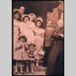 Priest with women and children on steps outside building (Maryknoll) (ddr-densho-330-183)