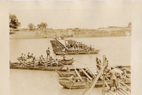 Soldiers building a pontoon bridge and moving through a field (ddr-njpa-6-89)